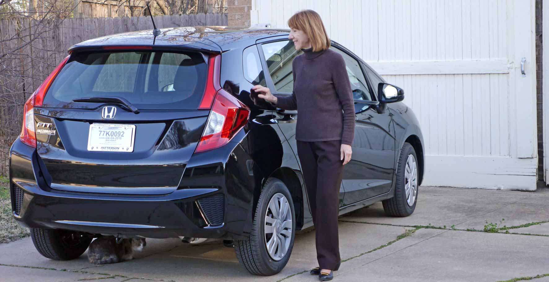 Anne Barone doing cat check before driving car. Kiri, the cat under car.