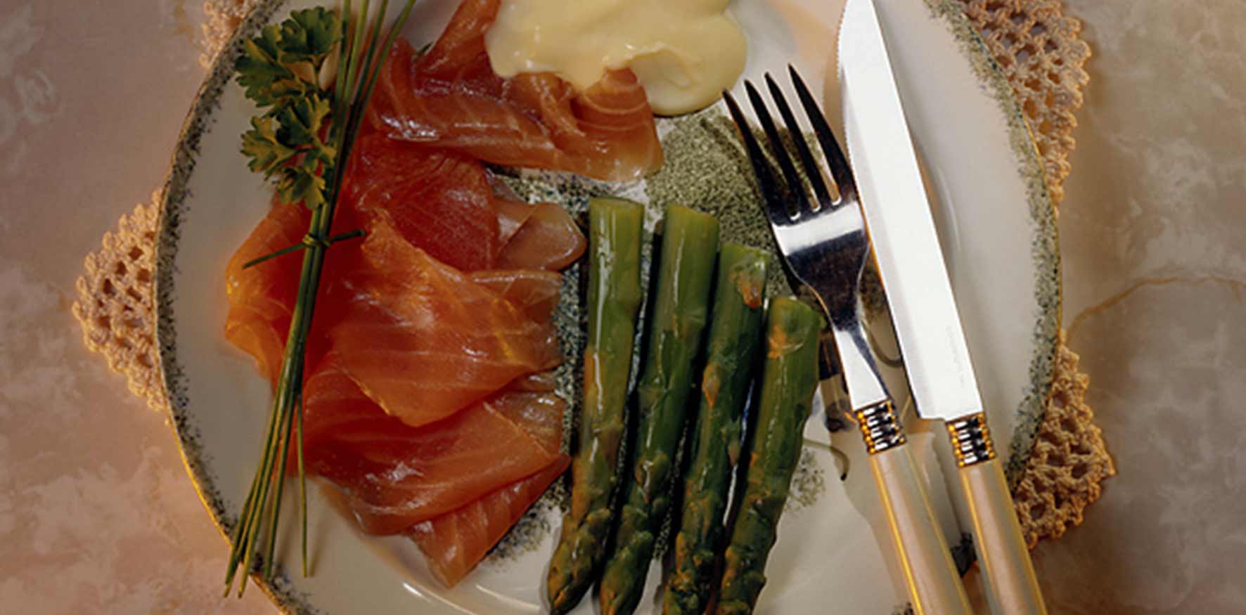 Plate with sliced salmon, asparagus, and mayonnaise sauce