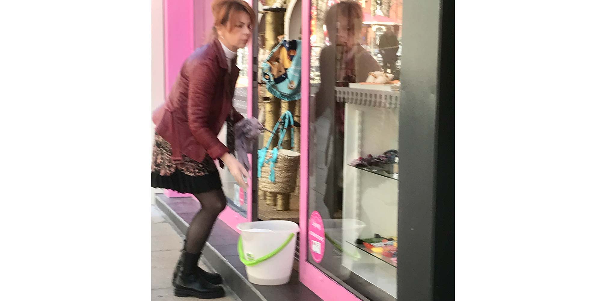 chic French shop owner washing shop windows