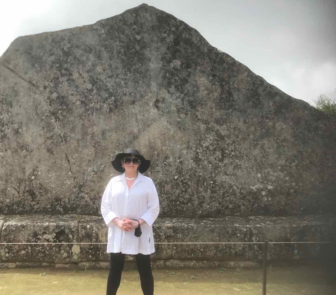 Chic woman in white shirt, black leggings, black sun hat and sunglasses