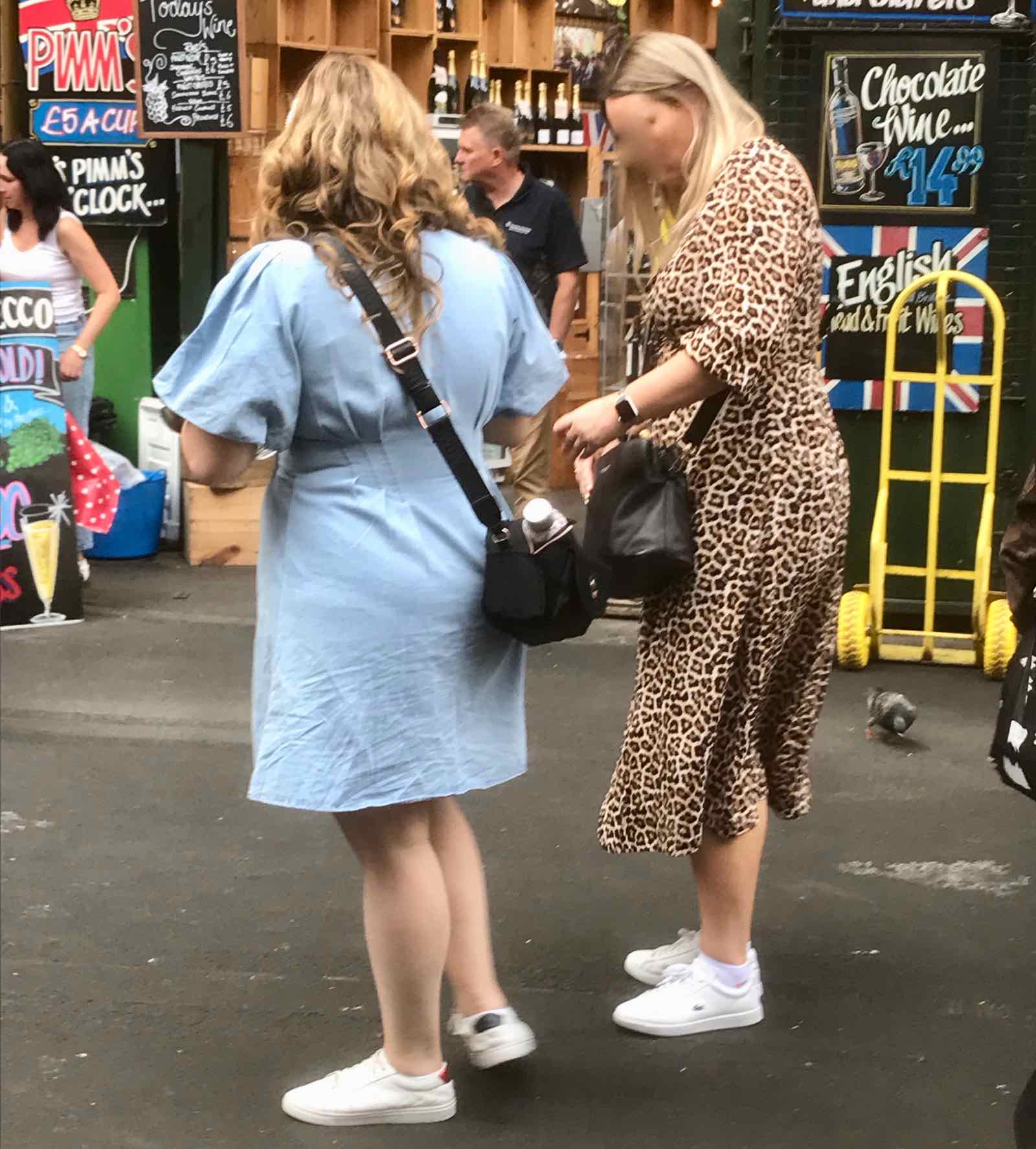 two women wearing summer dresses and white trainers (sneakers)