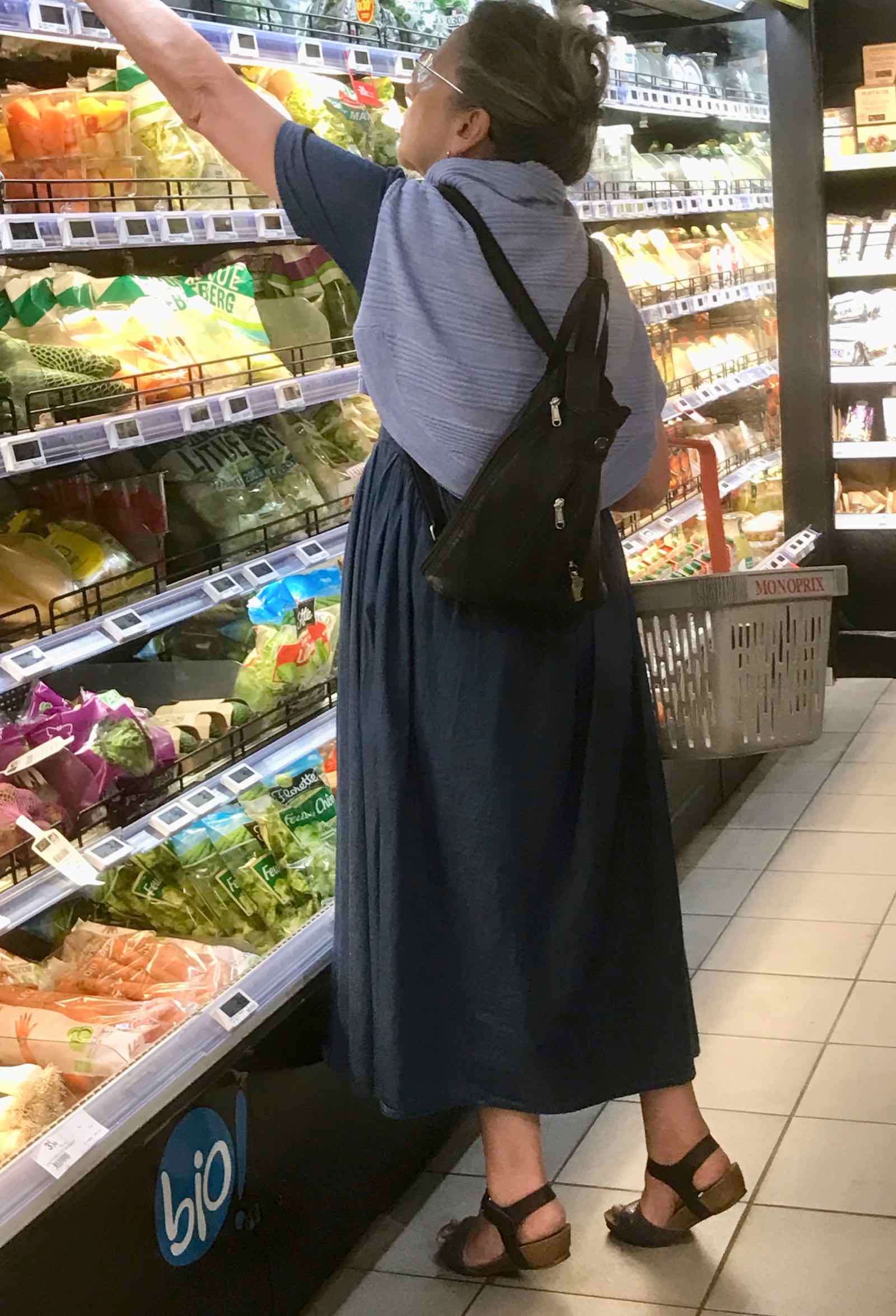 womam wearing navy ankle length dress with blue scarf and backpack