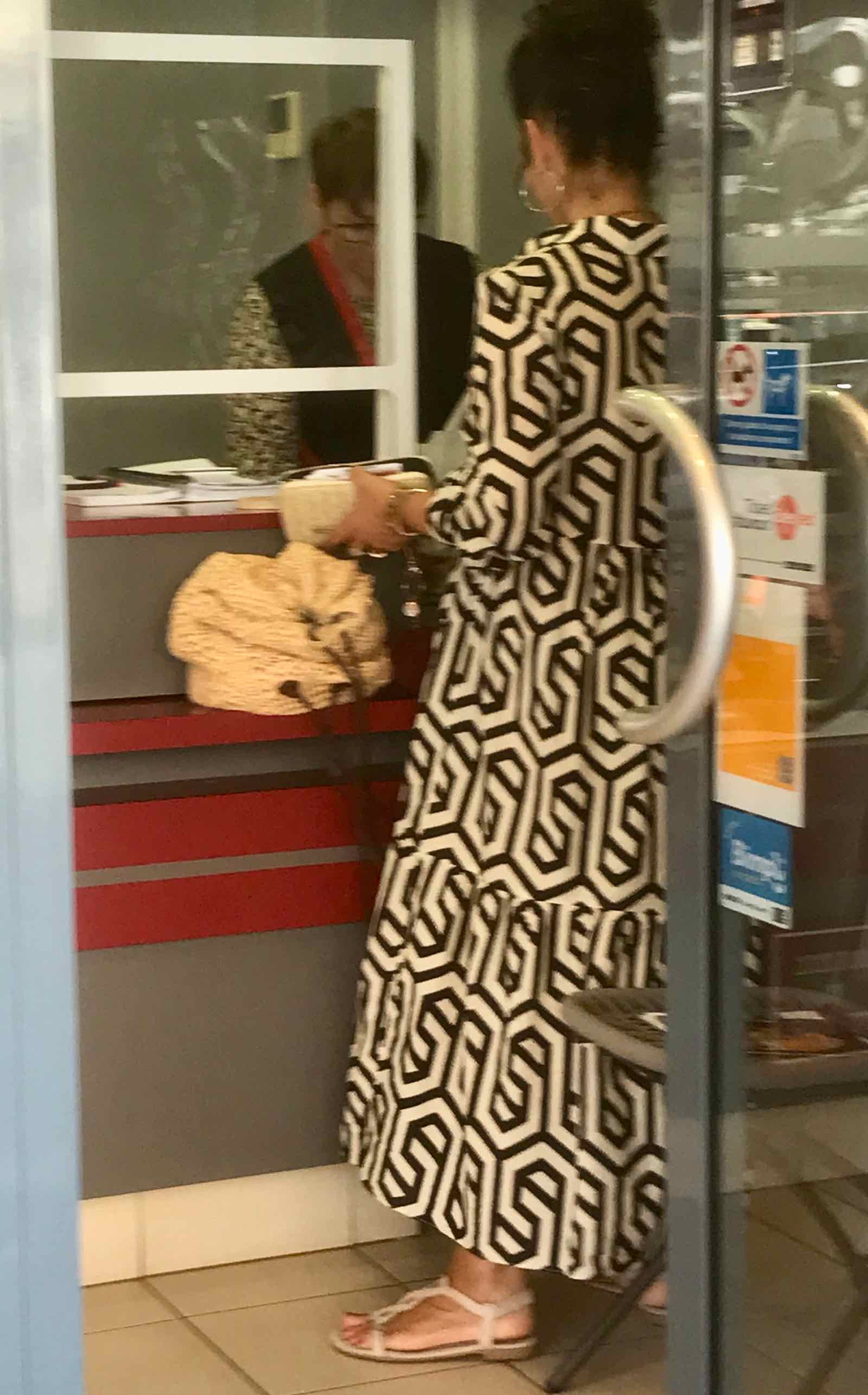 woman wearing black and white bold print dress and jacket with crystal beaded sandals