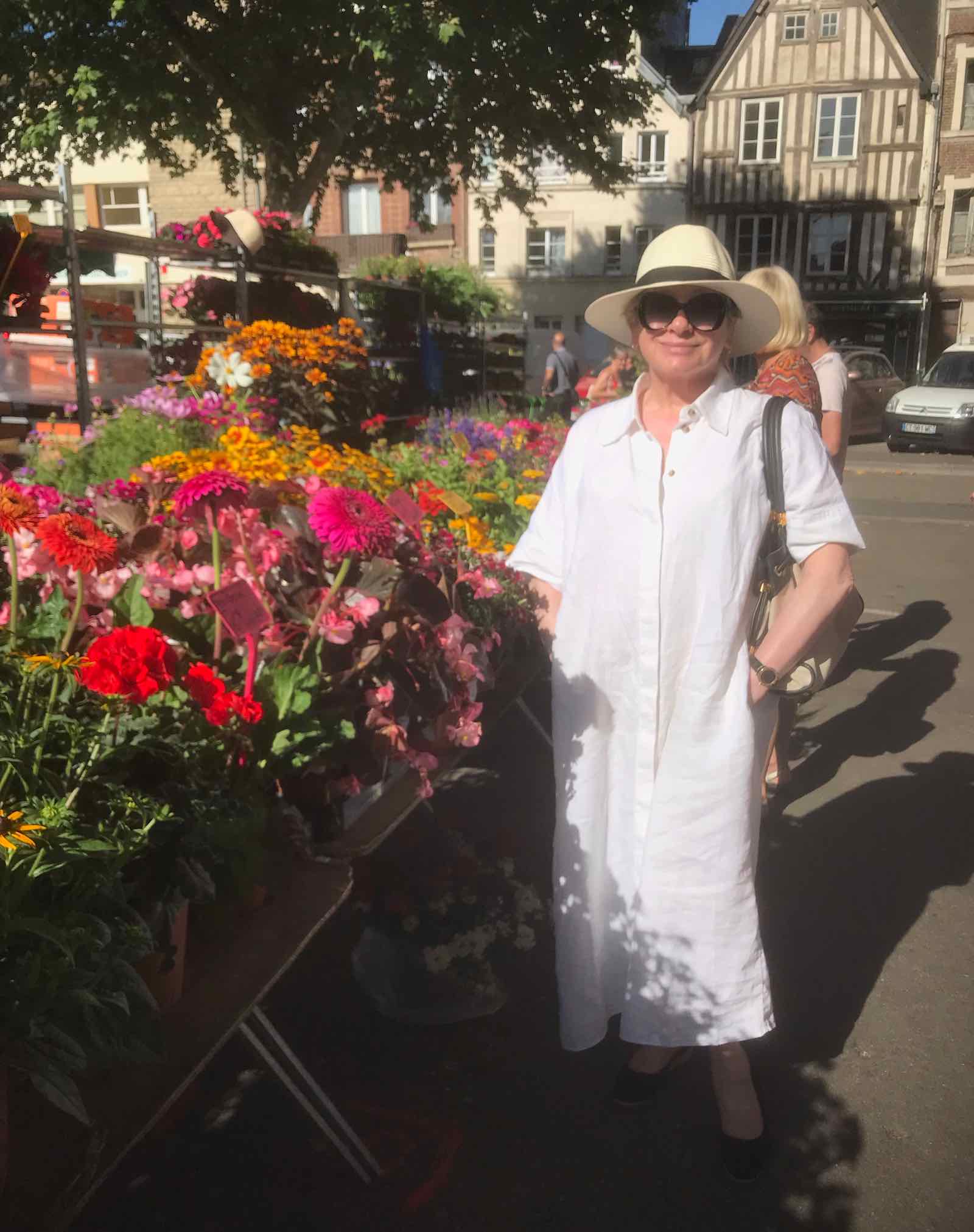 woman in white dress at flower stall