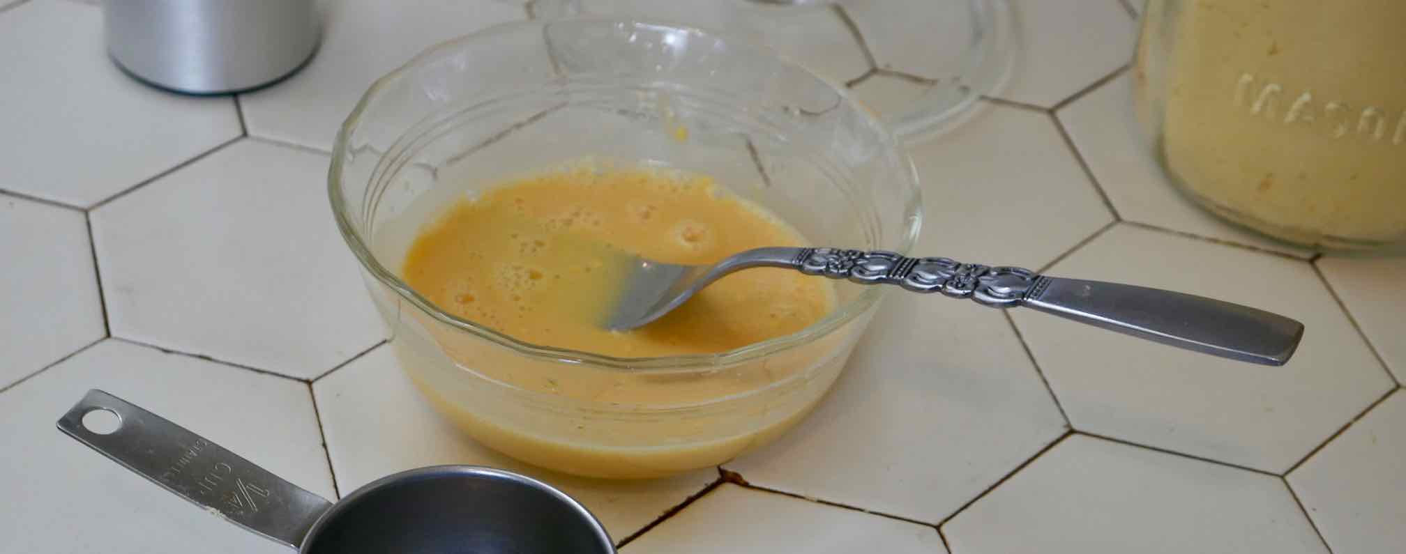 dried egg powder being mixed  with water using a fork