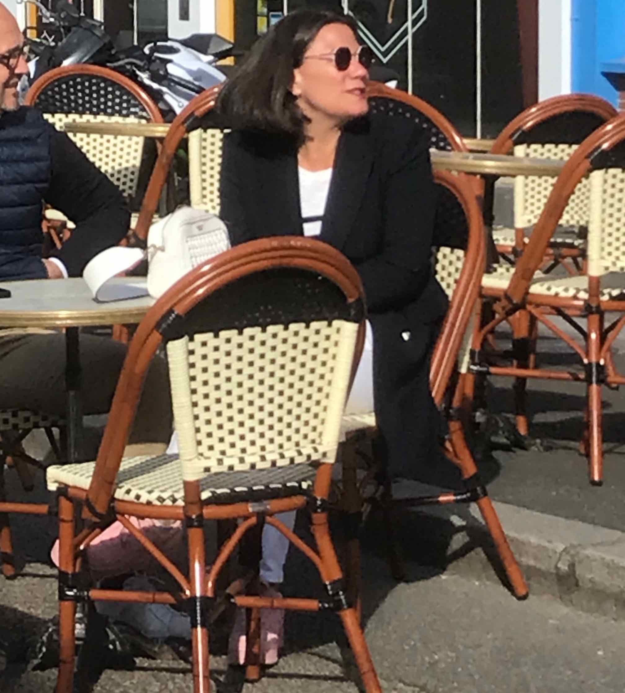 chic woman in sunglasses on cafe terrace